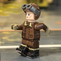 the left side of the Minifigure - German Red Baron Fighter Pilot (Leather Jacket Version) WWI (LEGO Compatible)